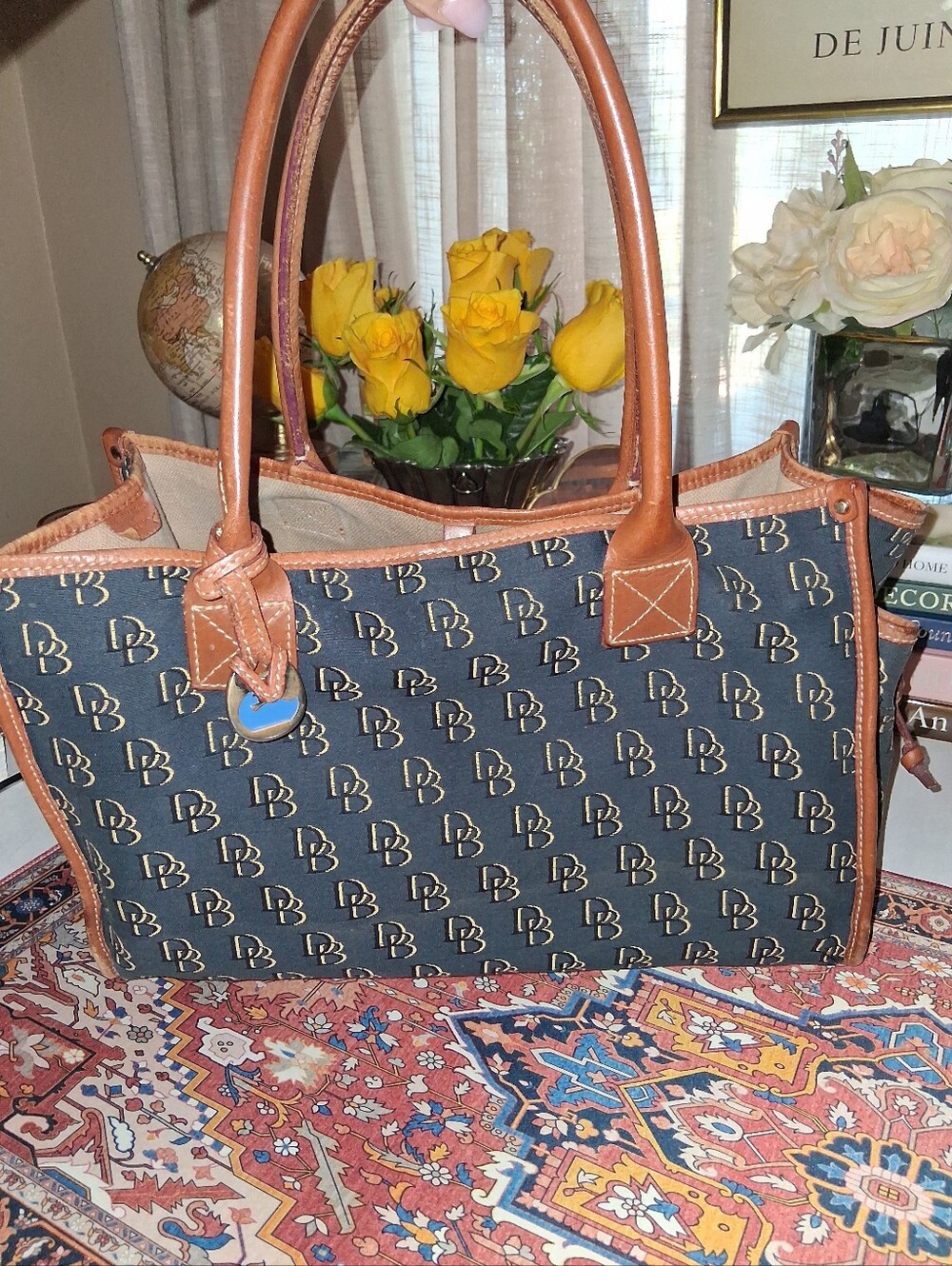 Dooney & Bourke Black tote bag with repeating monogram print and brown leather